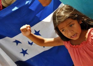 Menina participa de ato de apoio ao presidente de Honduras, Manuel Zelaya, nesta sexta-feira (30), em frente ao prédio do Congresso, em Tegucigalpa. (Foto: AFP)