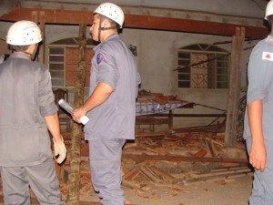 Bombeiros em casa que teve o telhado destruído no bairro Jardim Brasil(Foto: Michelly Oda/G1)
