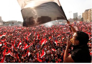Manifestantes contra o presidente egípcio, Mohamed Mursi levantam bandeiras nacionais na praça Tahrir, no Cairo