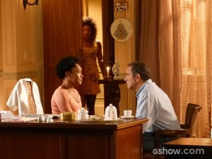 Alice ouve a conversa do tio e da mãe e se esconde ao perceber que falam dela (Foto: Em Família/TV Globo)